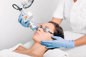 a woman receiving Laser treatment on her face